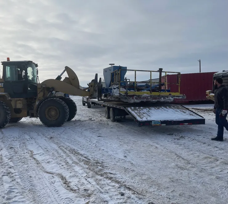Equipment loaded on flatbed trailer in winter conditions
